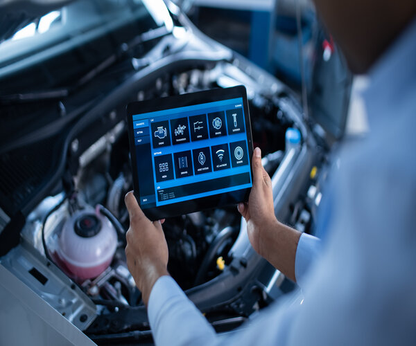 Car Service Manager or Mechanic Uses a Tablet Computer with a Futuristic Interactive Diagnostics Software. Specialist Inspecting the Vehicle in Order to Find Broken Components In the Engine Bay.